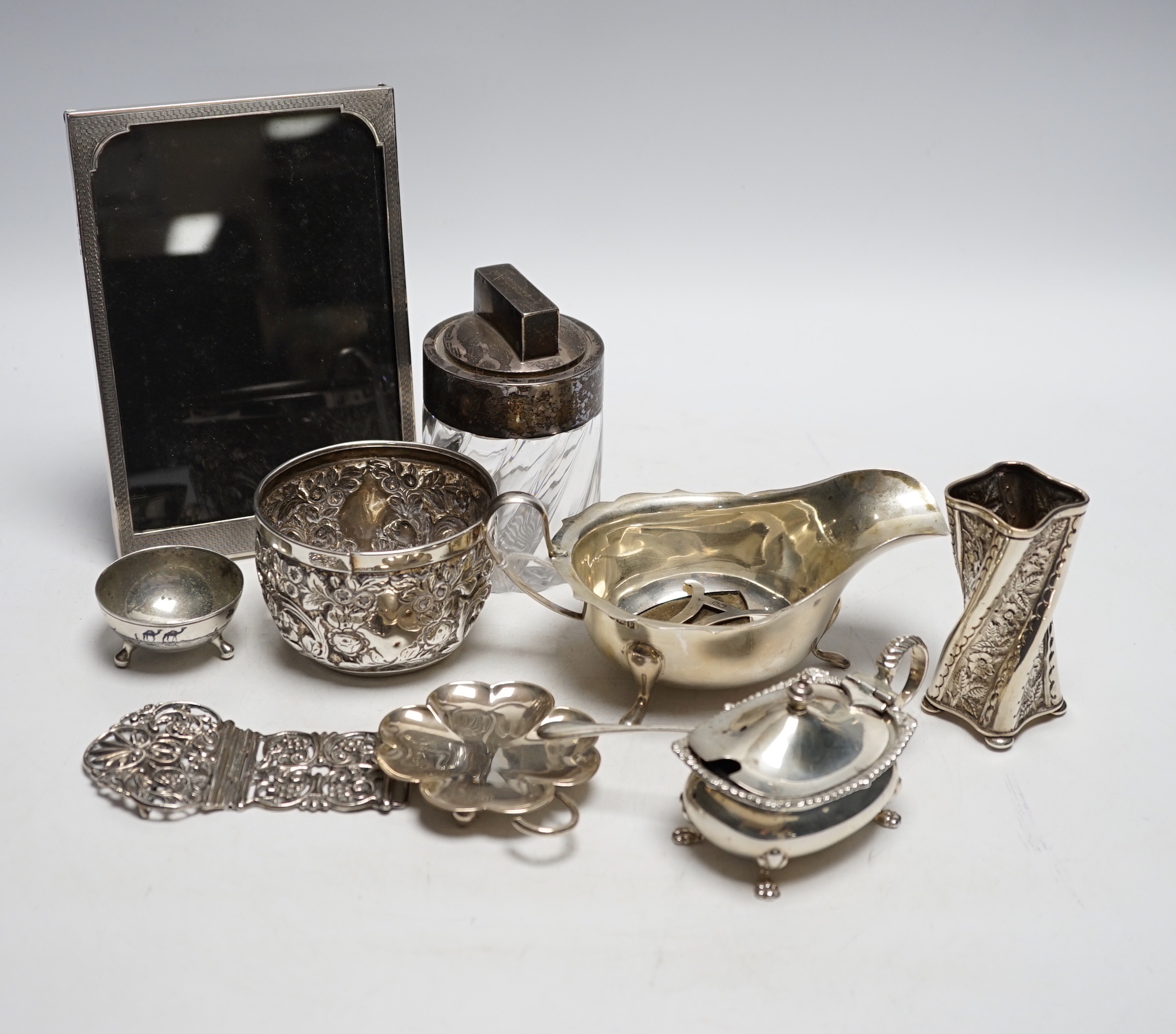 Assorted small silver including pair of silver sauceboats, a small jug and vase, a salts bottle, condiments, photograph frames, a matchbox sleeve, etc.
